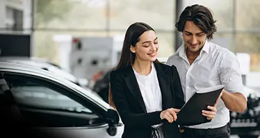Mujer especialista en servicio al cliente asesorando a usuario en concesionario Subaru.