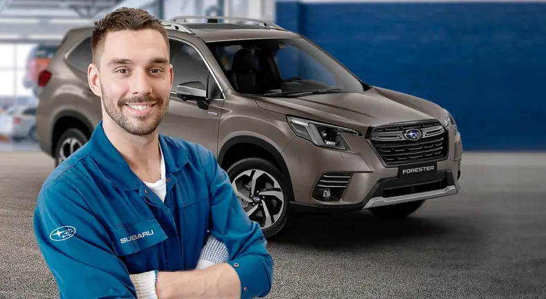 Experto automotriz Subaru frente a modelo Forester en taller mantenimiento.